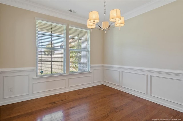 empty room with an inviting chandelier, crown molding, dark wood-style floors, and visible vents