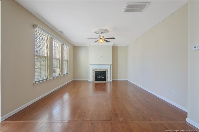 unfurnished living room with wood finished floors, visible vents, baseboards, and ceiling fan