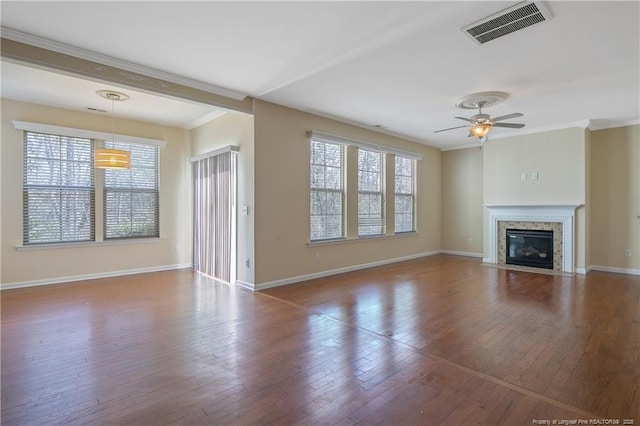 unfurnished living room with hardwood / wood-style floors, plenty of natural light, visible vents, and ceiling fan