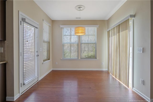 unfurnished dining area with visible vents, baseboards, and wood-type flooring