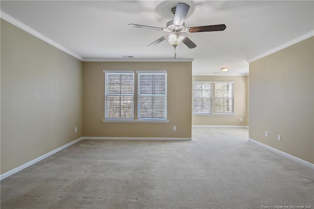 spare room featuring baseboards, crown molding, ceiling fan, and carpet floors