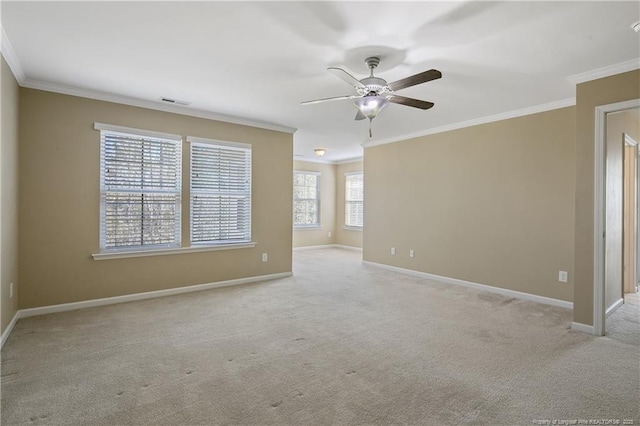 carpeted spare room with a ceiling fan, baseboards, and ornamental molding