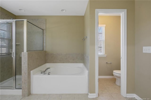 bathroom with toilet, a shower stall, tile patterned flooring, baseboards, and a bath