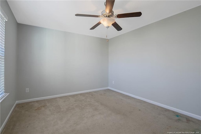 unfurnished room with light carpet, a ceiling fan, a wealth of natural light, and baseboards