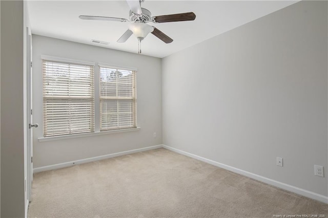 spare room with carpet flooring, baseboards, visible vents, and ceiling fan