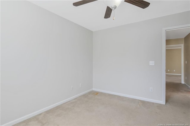 empty room with baseboards, light colored carpet, and ceiling fan