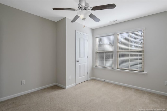 empty room featuring visible vents, baseboards, ceiling fan, and carpet flooring