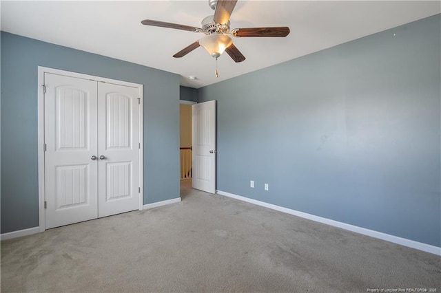 unfurnished bedroom with a closet, baseboards, carpet floors, and ceiling fan