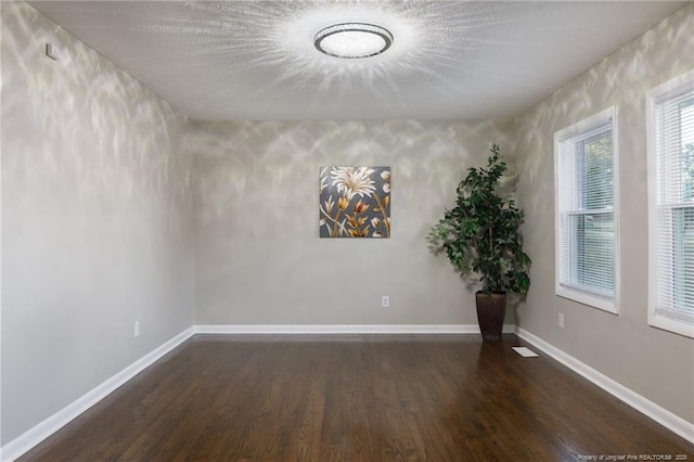 unfurnished room featuring baseboards and wood finished floors