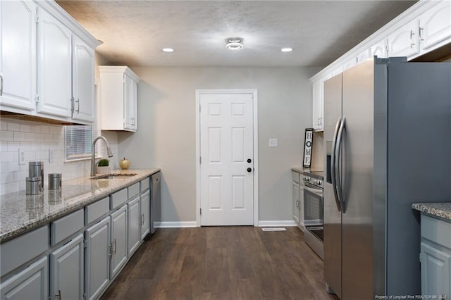 kitchen featuring a sink, white cabinets, backsplash, and stainless steel appliances