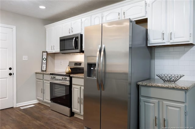 kitchen featuring dark wood finished floors, white cabinetry, stainless steel appliances, and tasteful backsplash