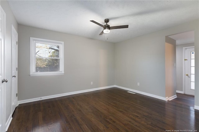 empty room featuring dark wood-style floors, baseboards, and a ceiling fan