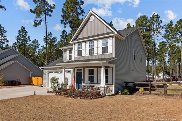 craftsman-style house with fence, driveway, a porch, an attached garage, and board and batten siding