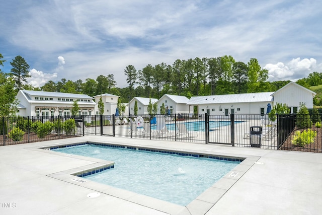 community pool with a patio and fence