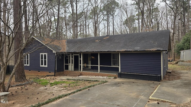 ranch-style house featuring crawl space, a shingled roof, and a sunroom