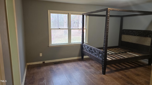 bedroom featuring visible vents, baseboards, and dark wood-style floors