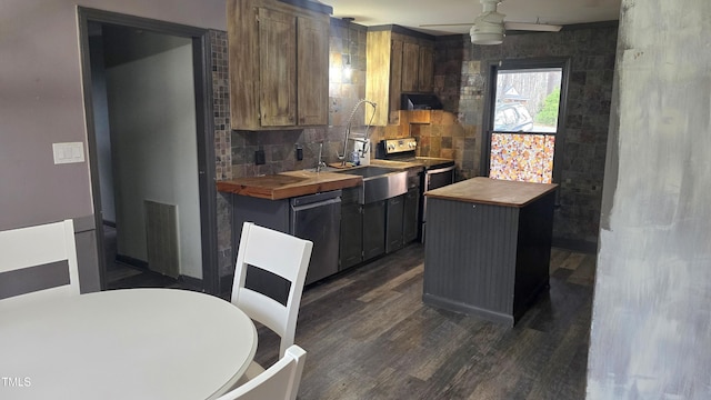 kitchen with visible vents, backsplash, dark wood-type flooring, stainless steel appliances, and wood counters