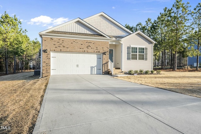 ranch-style house featuring central air condition unit, board and batten siding, concrete driveway, an attached garage, and brick siding