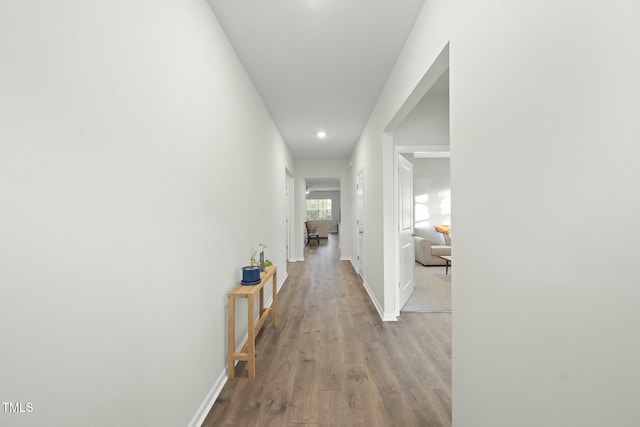 hall with baseboards and wood finished floors