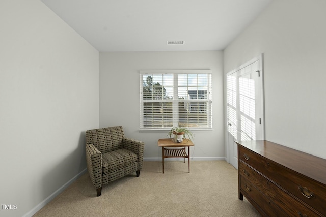 sitting room featuring visible vents, baseboards, and light colored carpet