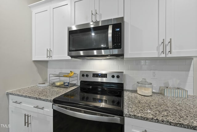 kitchen with stainless steel microwave, range with electric cooktop, and white cabinetry