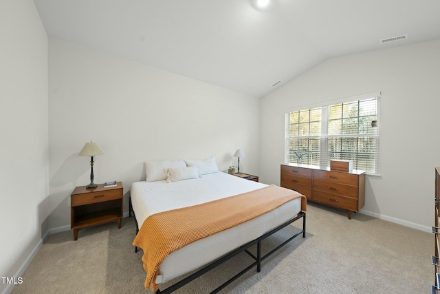 bedroom with lofted ceiling, baseboards, and light carpet