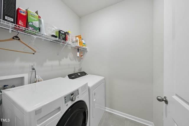 laundry room with washing machine and clothes dryer, laundry area, and baseboards