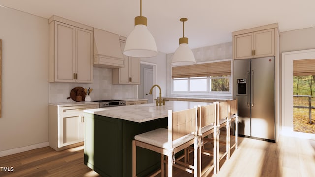 kitchen featuring light wood finished floors, tasteful backsplash, custom exhaust hood, high end fridge, and a sink