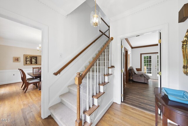 2705 Vestry Way, Raleigh, NC 27613 - stairway featuring ornamental molding, wood finished floors, a chandelier, french doors, and baseboards