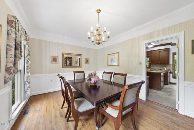 2705 Vestry Way, Raleigh, NC 27613 - dining area with plenty of natural light, wallpapered walls, a chandelier, ornamental molding, and light wood-type flooring