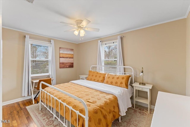 bedroom featuring baseboards, ceiling fan, crown molding, and hardwood / wood-style flooring