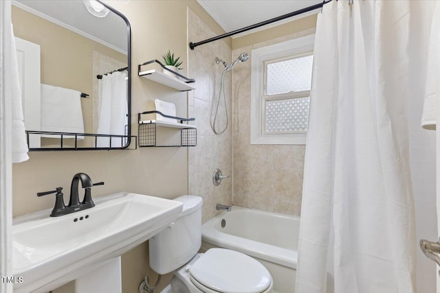 bathroom with toilet, shower / bath combo with shower curtain, and a sink