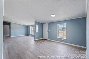 interior space with wood finished floors, baseboards, and a textured ceiling