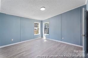 spare room featuring wood finished floors and baseboards