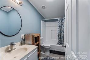 bathroom with shower / tub combo, toilet, and vanity