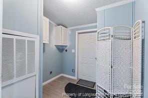 clothes washing area with wood finished floors and baseboards