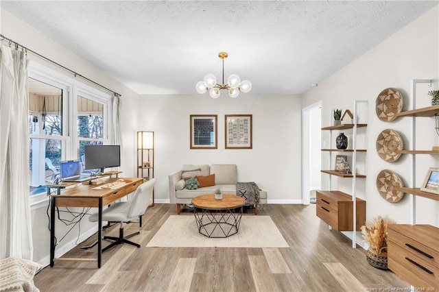 home office with a notable chandelier, wood finished floors, baseboards, and a textured ceiling