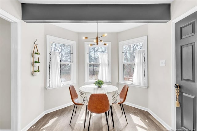 dining room with baseboards, an inviting chandelier, and wood finished floors