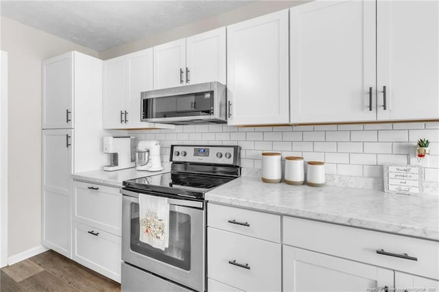 kitchen featuring tasteful backsplash, dark wood finished floors, white cabinetry, and stainless steel appliances