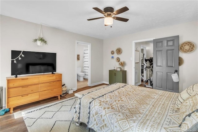 bedroom with ceiling fan, ensuite bathroom, baseboards, and wood finished floors