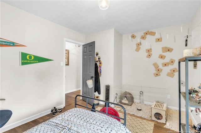 bedroom with wood finished floors and baseboards