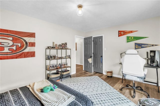 bedroom with wood finished floors and baseboards