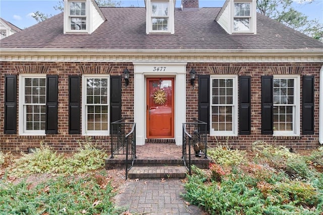 property entrance with brick siding and roof with shingles