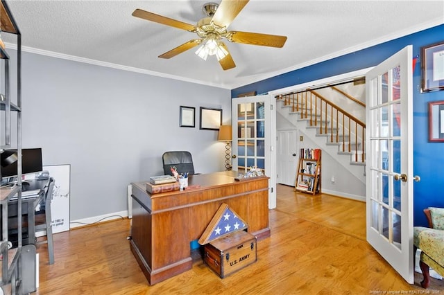 home office with french doors, light wood-type flooring, a ceiling fan, and ornamental molding