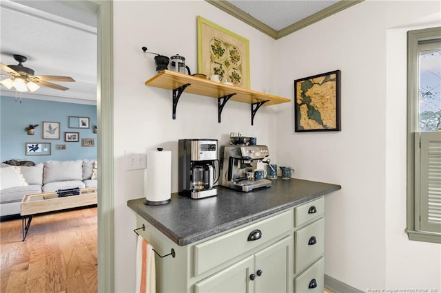 bar with crown molding, light wood-type flooring, and ceiling fan