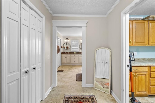 hallway with baseboards, a textured ceiling, and crown molding