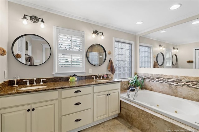 bathroom with a sink, a jetted tub, ornamental molding, and double vanity