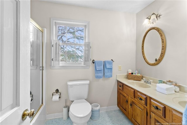 full bathroom with baseboards, toilet, vanity, and bath / shower combo with glass door