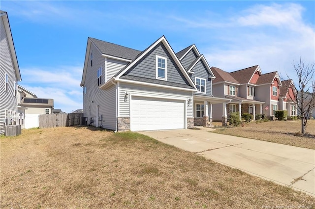 craftsman-style house with fence, central AC, a garage, stone siding, and driveway