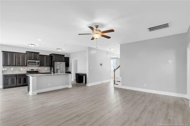 kitchen with open floor plan, ceiling fan, appliances with stainless steel finishes, and visible vents